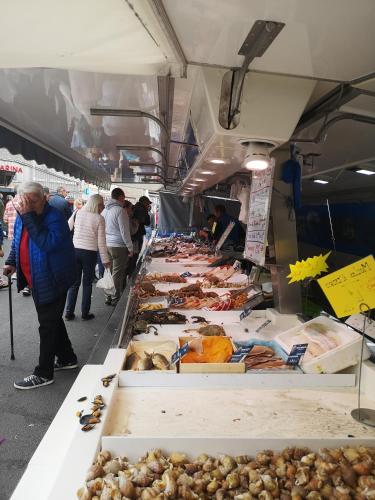 Un groupe de personnes se promenant autour d'un marché alimentaire dans l'établissement La maison du bonheur, à Port-en-Bessin-Huppain