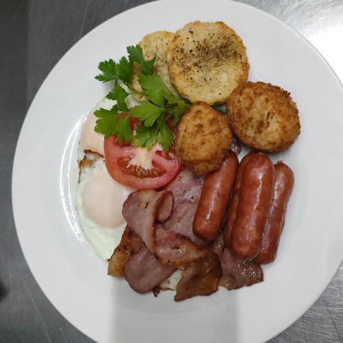 a plate of breakfast food with sausage potatoes and eggs at Acacia Gastehuis in Kathu