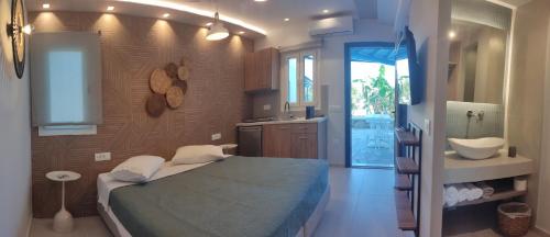 a bedroom with a bed and a bathroom with a sink at Casa di Angela in Mikonos