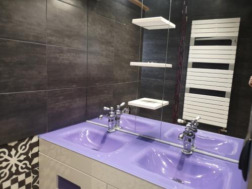 a bathroom with a blue sink and a mirror at La maison du bonheur in Port-en-Bessin-Huppain