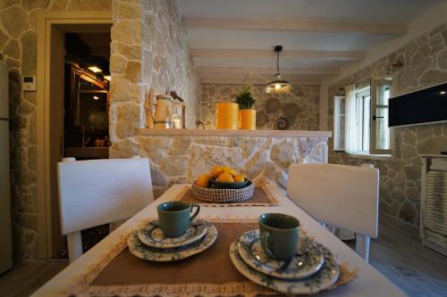 a table with two cups and a bowl of fruit on it at TheHouse1905 in Parga