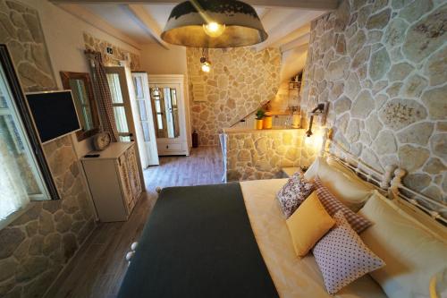 a bedroom with a bed with a stone wall at TheHouse1905 in Parga