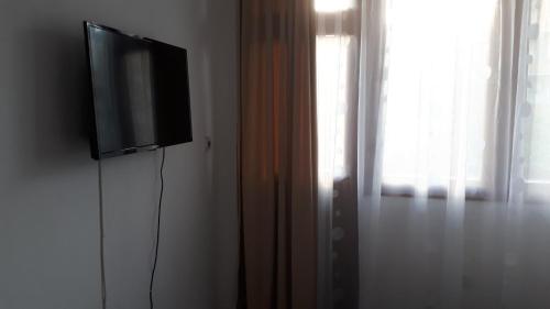 TV de pantalla plana en una pared junto a una ventana en Margo, en Sozopol
