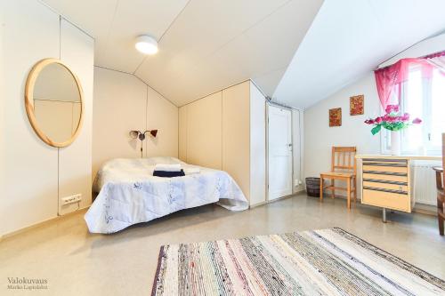 een slaapkamer met een bed en een spiegel bij Raate Guest House in Suomussalmi