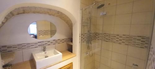 ein Bad mit einem Waschbecken und einem Spiegel in der Unterkunft Le cottage du village in Seigny