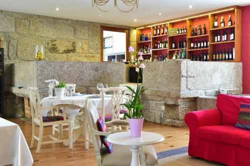 a restaurant with a table and a red couch at Solar Egas Moniz-Charming House & Local Experiences in Paço de Sousa