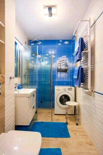 a bathroom with a sink and a washing machine at BALTIC SUNSHINE in Świnoujście