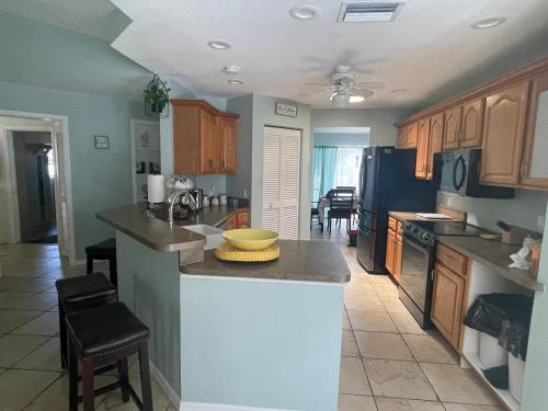 a kitchen with wooden cabinets and a counter top at Melody 3-Bedroom Pool Villa close to the beach!!! in Port Charlotte