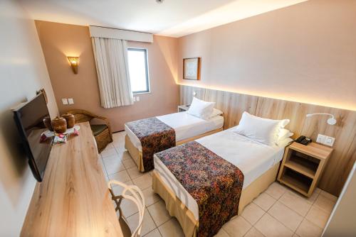Ένα ή περισσότερα κρεβάτια σε δωμάτιο στο Hotel Sonata de Iracema