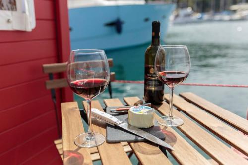 dos vasos de vino tinto sentados en una mesa de picnic en House boat R al Poetto 2 pax piu' 1, en Poetto