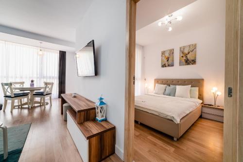 - une chambre avec un lit et une salle à manger dans l'établissement Bliss M&M by Onix Blue, à Mamaia Nord – Năvodari