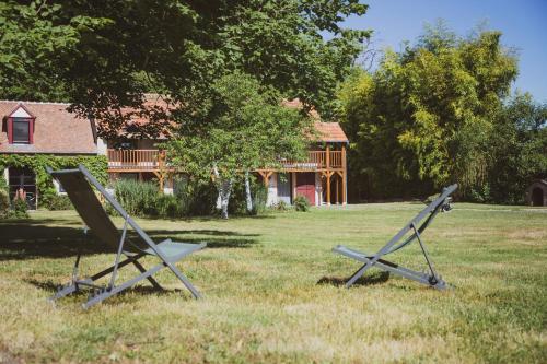 two metal objects in the grass in front of a house at Domaine de Montizeau in Lailly-en-Val