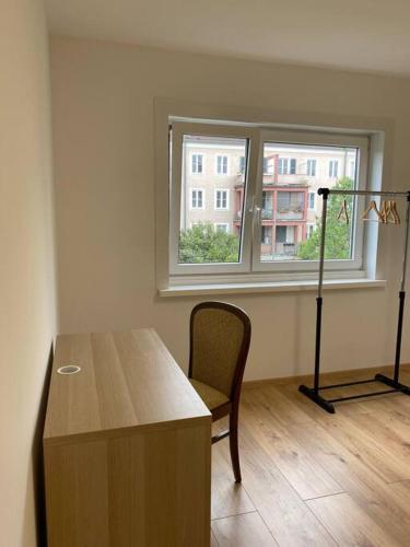 Zimmer mit einem Tisch, einem Stuhl und einem Fenster in der Unterkunft Bezaubernde Wohnung in Wolfsburg Stadtnah in Wolfsburg