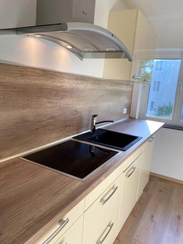 eine Küche mit einer Spüle und einer Arbeitsplatte in der Unterkunft Bezaubernde Wohnung in Wolfsburg Stadtnah in Wolfsburg