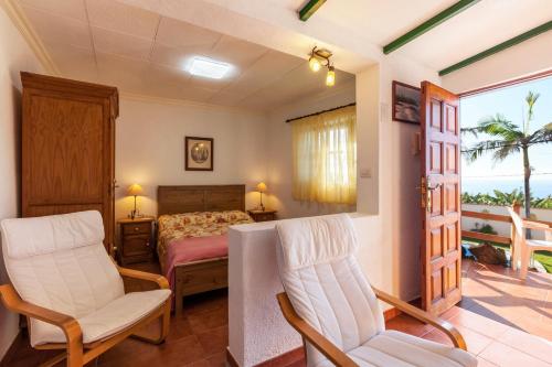 a bedroom with a bed and two chairs and a window at Casa Victor - Apartment Jorge in La Orotava