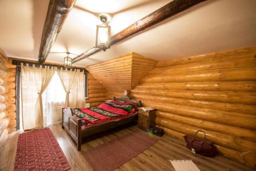 a room with a bed and a wooden wall at The Lodge in Moieciu de Jos