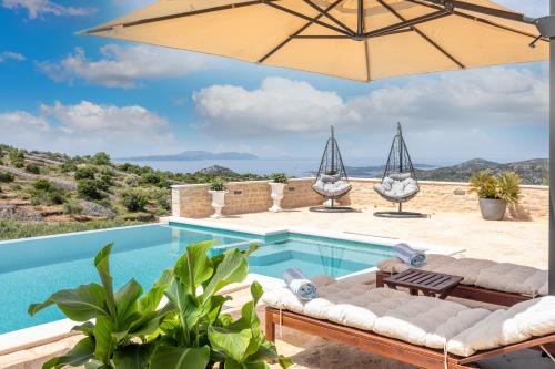 a swimming pool with an umbrella and chairs and a pool at Vidikovac Levanda Luxury Apartments in Hvar