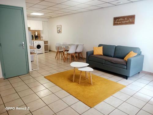 a living room with a couch and a table at Le petit Cosy in Saint-Laurent-de-la-Salanque