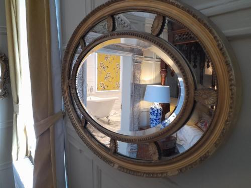a mirror on a wall with a lamp in a room at Stone Court House in Maidstone