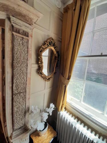 a mirror on a wall next to a window at Stone Court House in Maidstone