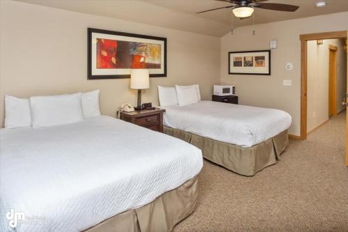 a hotel room with two beds and a ceiling fan at Kenai Airport Hotel in Kenai