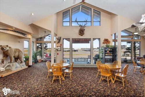 a room with tables and chairs and a large window at Kenai Airport Hotel in Kenai