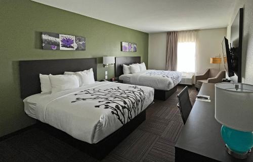 a hotel room with two beds and a window at Sleep Inn Dallas Northwest - Irving in Dallas