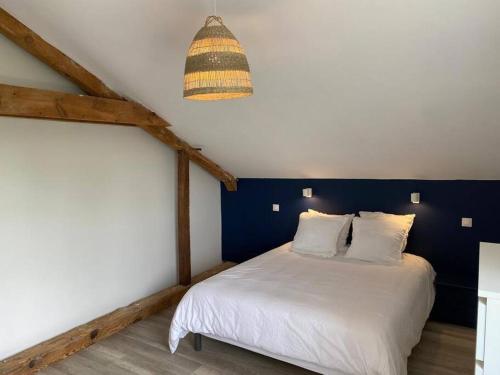 ein Schlafzimmer mit einem weißen Bett und einer blauen Wand in der Unterkunft Le Grand Marguit*** sur la Côte Basco-Landaise in Tarnos