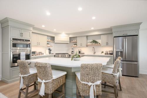 a kitchen with a large white island with chairs at Thomas Sea Suites at Harbourtown in Plymouth