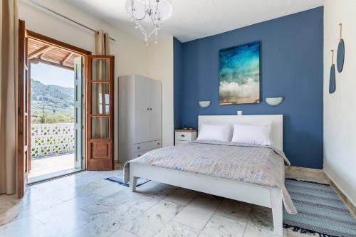 Dormitorio azul con cama y pared azul en Estia A - Studios & Apartments en Skopelos Town