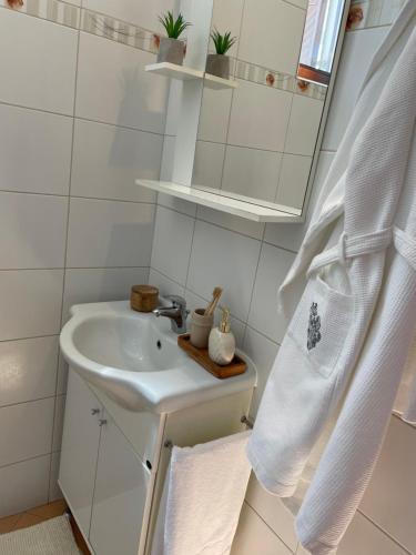 a white bathroom with a sink and a mirror at Lav apartment & studios in Pula