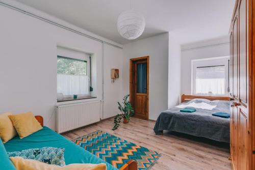 um quarto com 2 camas e um sofá em Róka Porta em Szentkirályszabadja