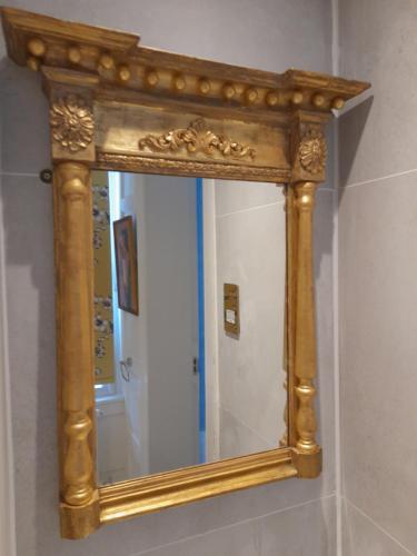 a mirror with a wooden frame on a wall at Stone Court House in Maidstone