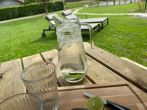 a bottle of water and a glass on a wooden table at Le Grand Marguit*** sur la Côte Basco-Landaise in Tarnos