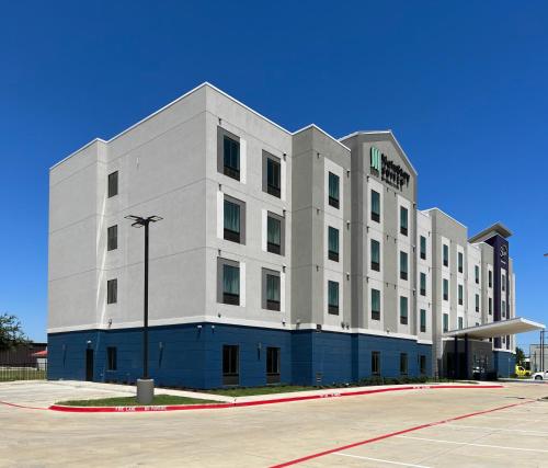 un edificio bianco con un lampione davanti di MainStay Suites Dallas Northwest - Irving a Dallas