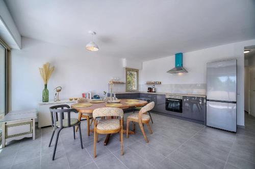 - une cuisine avec une table et des chaises en bois dans l'établissement IMMOGROOM -  Vue mer - Piscine - Terrasse - Parking - Au Calme, à Cannes