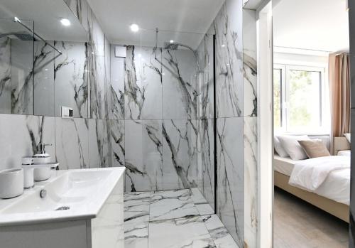 a bathroom with a white sink and a shower at Apartamenty Modrzewiowa Zator in Piotrowice