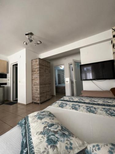 a bedroom with a large bed and a kitchen at Vila Andra in Eforie Nord