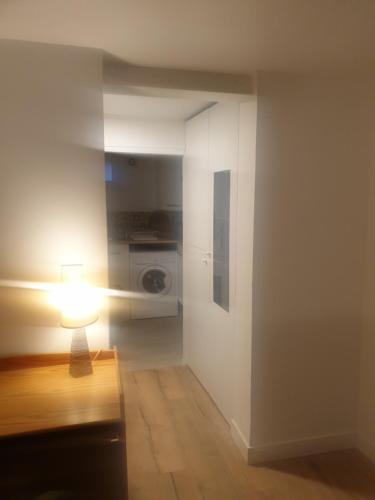 Habitación blanca con una lámpara en una mesa en Studio 25m2 indépendant sous-sol, en Sarcelles