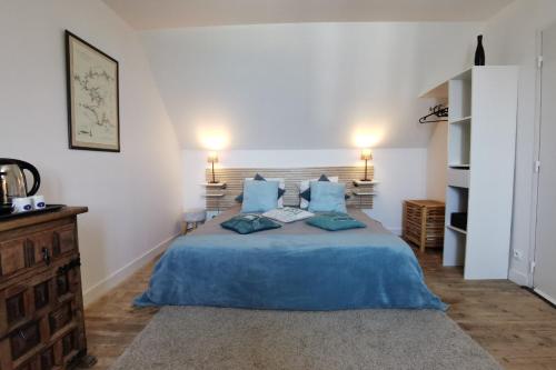 une chambre avec un grand lit bleu avec des oreillers bleus dans l'établissement ABORD- Vue sur mer, baie de Morlaix, grande maison, école de voile à 100m, à Plougasnou