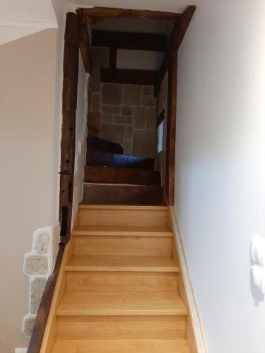 un escalier dans une maison avec un mur en pierre dans l'établissement La maison d Eugene, à Clermont-Créans