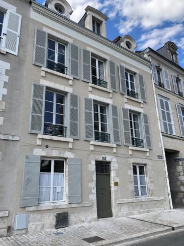 a building with gray shuttered windows and a door at Au 16 Place Saint Louis in Blois