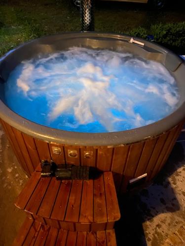 a hot tub filled with blue water with a wooden table at Droom b&b Čermná in Čermná