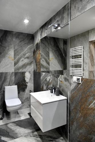 a bathroom with a white sink and a toilet at Apartamenty Modrzewiowa Zator in Piotrowice