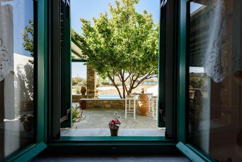 a window view of a patio with a tree at seaside Ktima KaParos PAROS in Drios