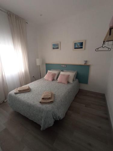 a bedroom with a bed with two towels on it at Casa Reyes in Rota