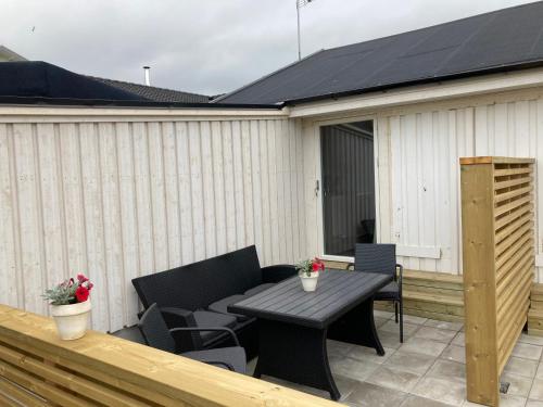 a patio with a table and chairs on a deck at Gustavsro i Apelviken Annex 2 in Varberg