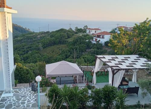 a view of a garden with a tent and a hill at Iordanis house- Traditional House in old Alonnisos in Alonnisos Old Town