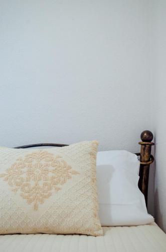 a pillow on a bed with a white wall at La Minditta in San Teodoro
