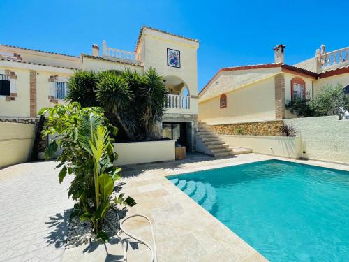 a villa with a swimming pool in front of a house at Casa Azure in Gran Alacant
